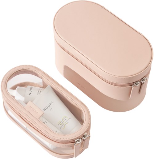 Eine hellrosa Kosmetiktasche mit Reißverschluss, enthält Hautpflegeprodukte, und eine passende ovale Tasche.