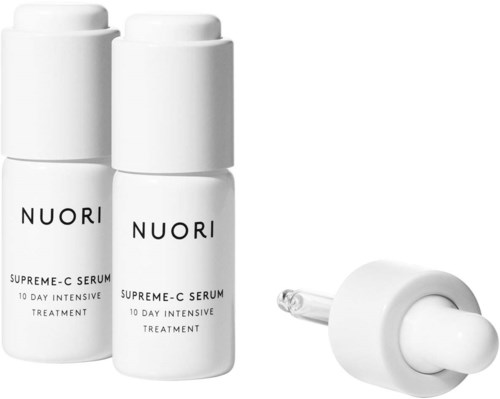 Zwei weiße Flaschen mit den Aufschriften "NUORI" und "Supreme-C Serum," daneben eine Pipette.