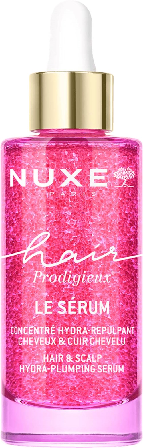 Pink hair serum bottle with white and gold cap, labeled Nuxe Hair Prodigieux. It contains hydrating and revitalizing ingredients.