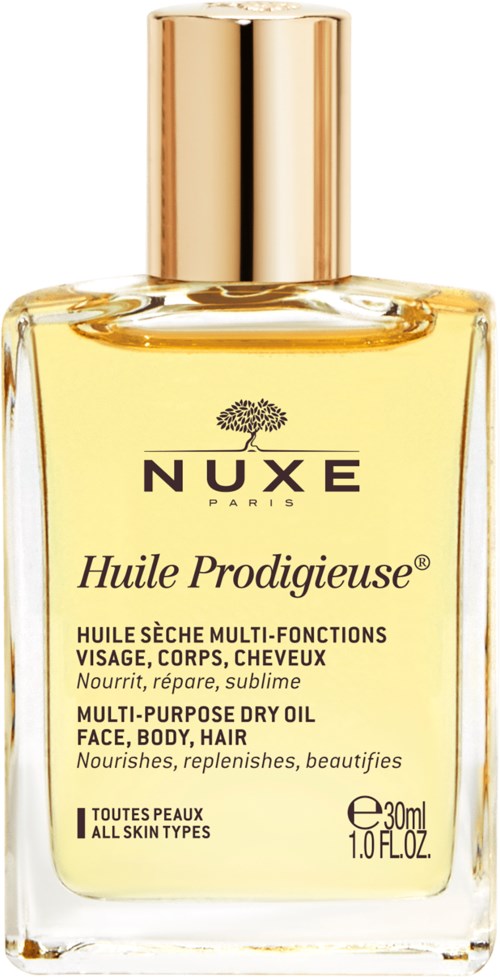 A glass bottle of Nuxe Huile Prodigieuse dry oil with a golden cap, labeled for face, body, and hair care.