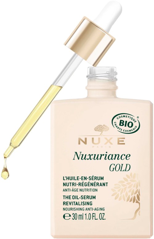 A bottle of skincare serum with a dropper, labeled Nuxe Nuxuriance Gold, containing nourishing and anti-aging ingredients.