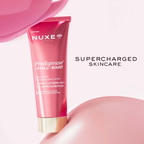 En rosa tub med Nuxe-vårdinlägg på en rosa yta med text som lyfter fram "superladdad hudvård".
