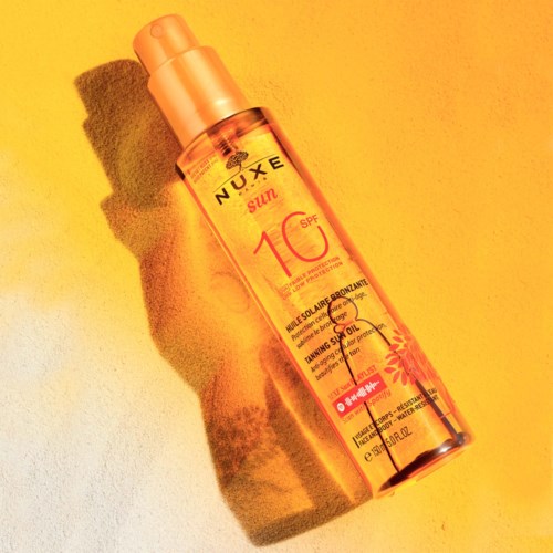 A sunscreen spray bottle with SPF 10, orange color, and sun protection label on a yellow background.