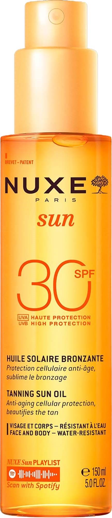 En lång orange flaska med Nuxe solbränneolja med SPF 30, märkning för ansikte och kroppsskydd, ser glansig och slät ut.