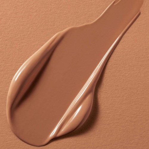 Een beige make-upkwast met een glanzende handgreep ligt op een bijpassende achtergrond.