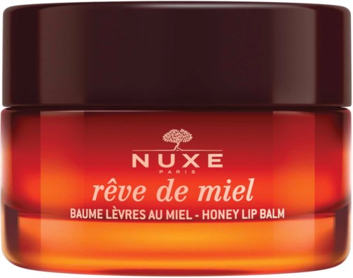 A small jar of honey lip balm by Nuxe Paris with red and orange colors and a black lid.