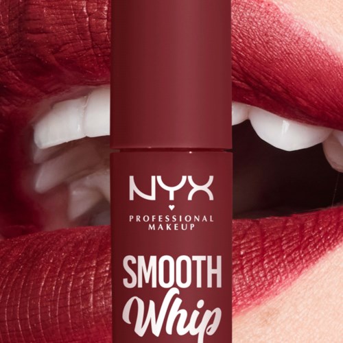 Ein Lippenstift ist vor Lippen mit kräftigem rotem Lippenstift, teilweise geöffnet, zeigt weiße Zähne.