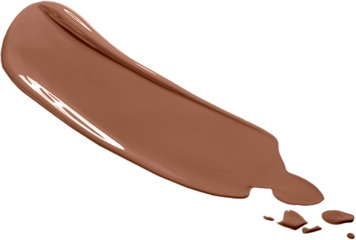 Ein Streifen brauner Make-up oder Lotion ist auf einem weißen Hintergrund verteilt, mit einigen zerbrochenen Teilen in der Nähe.