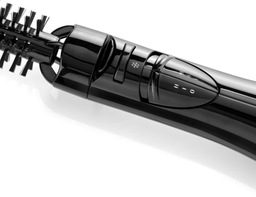 A curling iron with a digital control, a handle, and a clamp to style hair.
