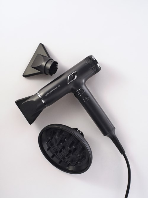A black hair dryer with a wide nozzle, stand, and diffuser attachment, all on a white background.