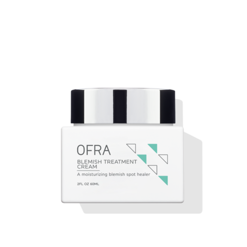 Ein weißer Behälter mit schwarzem und weißem Deckel, beschriftet mit OFRA Blemish Treatment Cream, mit grünen Dreiecken auf dem Etikett.
