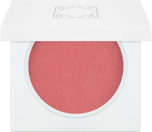 De afbeelding toont een blushcompact met roze poeder in een witte bewaardoos, en een gevouwen deksel met symbolen op.