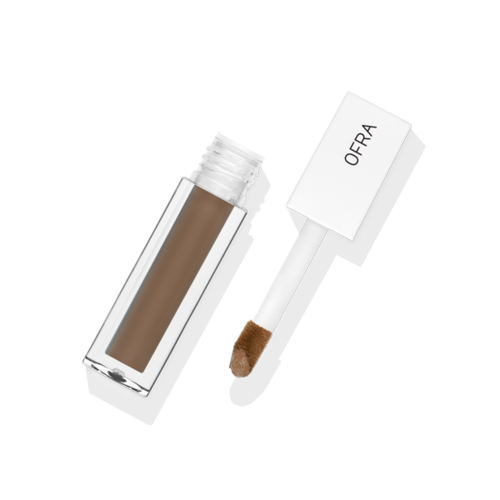 Concealer in a clear tube with a white applicator, labeled 'OFRA,' on a black background.