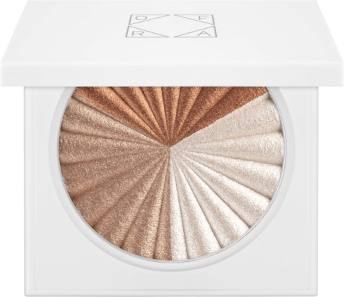 Een make-up highlighter pallet met vier tinten: brons, goud, roze en wit, in een wit kastje.