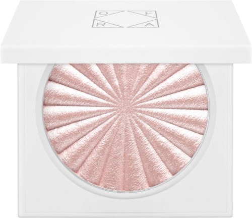 Een roze, glanzende blush met zonnestralenpatroon in een witte verpakking met logo bovenaan.