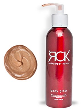 En röd kroppslotionflaska med pump och en klick brunt kräm bredvid.