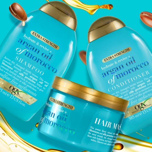 Three blue bottles of hair care products, including shampoo, conditioner, and hair mask, with gold caps and labels.