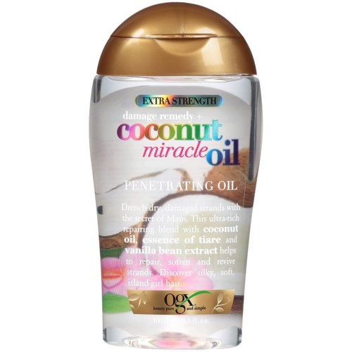 A clear bottle containing coconut miracle oil with a gold cap, labeled for damaged hair repair and softening.