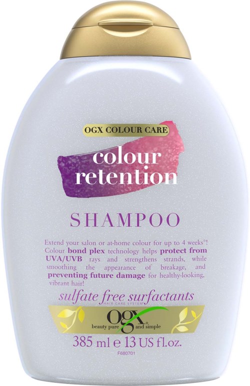 Witte fles met paarse en gele label, gouden dop, en tekst over shampoo voor haarverfverzorging.