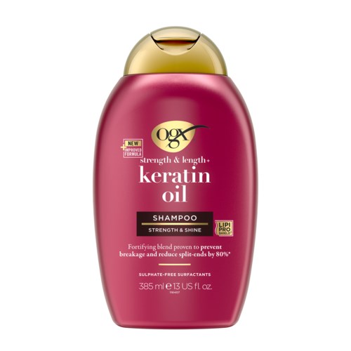 Een roze fles OGX keratine olie shampoo met een gouden dop, benadrukt kracht, glans en voorkoming van gespleten haarpunten.