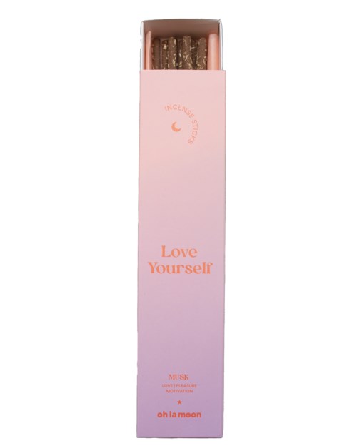 Pitkä vaaleanpunainen rasia, jossa on kynttilöitä, ja tekstit "Love Yourself" ja "oh la moon."