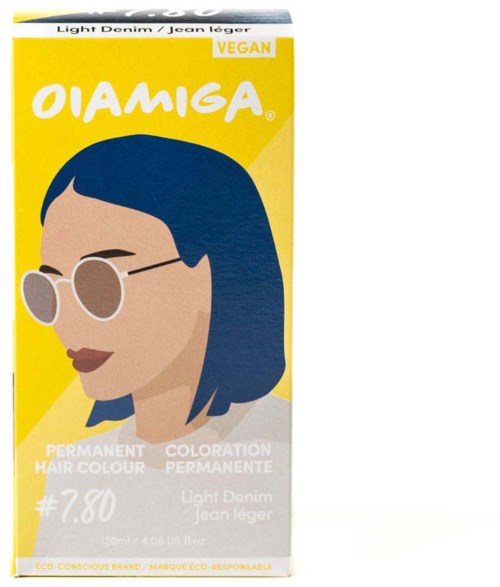 Verpakking met een vrouwelijk figuur, bril, gele achtergrond, en tekst over vegan haarkleur. Merknaam OIAMIGA.