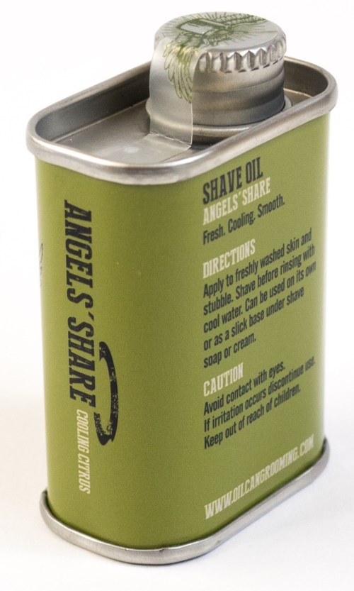 Small green container with a metallic lid, labeled for shave oil, with instructions and caution text.