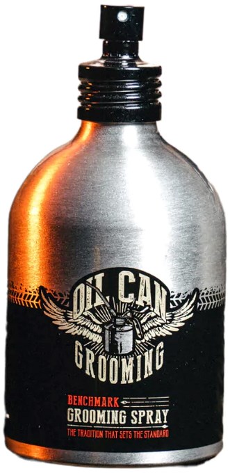 A silver bottle with a black cap, featuring a logo that says 'On Call Grooming' and 'Grooming Spray.'