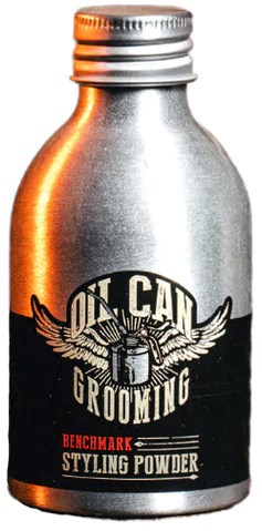 A small silver container labeled 'OIL CAN GROOMING' and 'BENCHMARK STYLING POWDER' with wings and a lock logo.