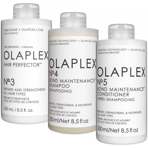 Drie haarverzorgingsflesjes: shampoo, conditioner en herstel- en versterkingsbehandeling. Witte flessen met zwarte tekst.