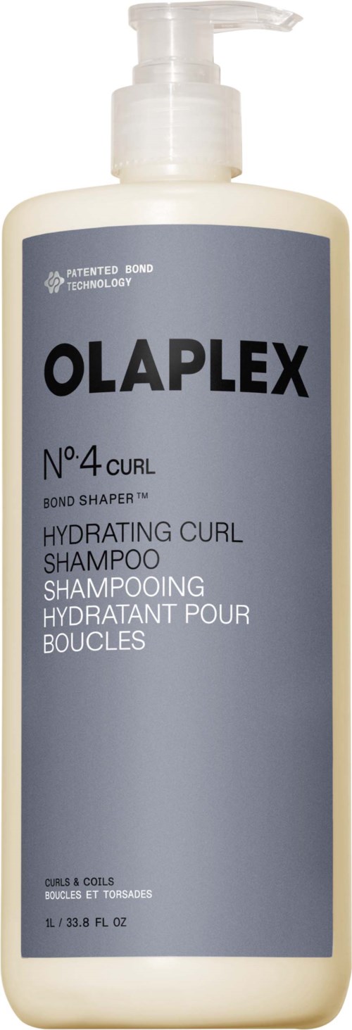 Pitkä beigen värinen pumppupullo, jossa lukee Olaplex No 4 Curl Hydrating Shampoo, sinisellä ja mustalla tekstillä.