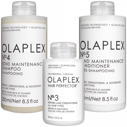 Drie haarverzorgingsflessen: shampoo, conditioner en haarherstel, allemaal van Olaplex, met labels die hun gebruik aangeven.