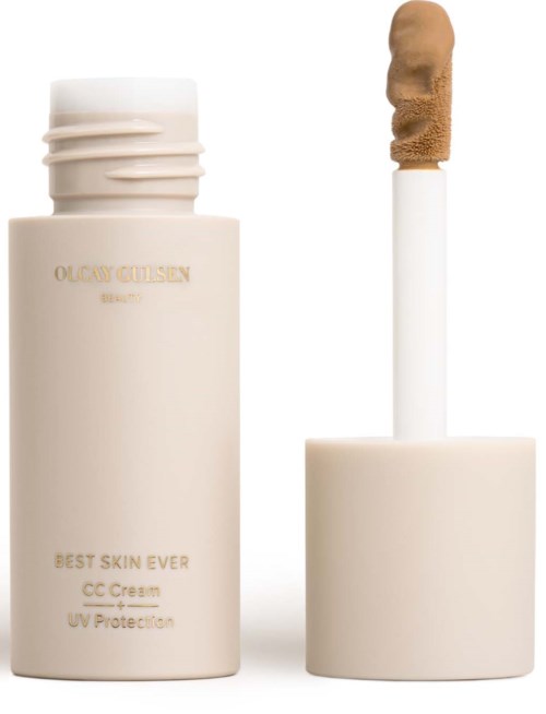 Een beige flesje met huidverzorgingscrème en een applicatorstaaf klaar voor gebruik.
