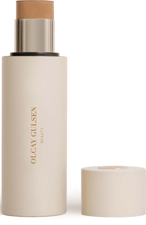 Een crèmekleurige fles met het label Olcay Gulsen Beauty en een beige dop ernaast.