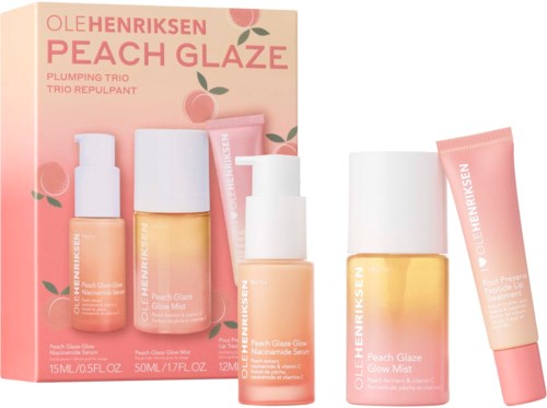 Perzik huidverzorgingsset met flesjes, een doos en een tube, allemaal met perzik- en roze kleuren en huidverzorgingslabels.