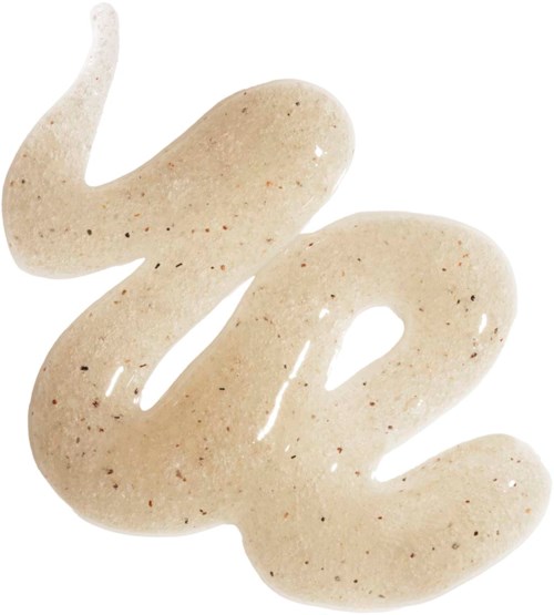 Crèmekleurige lotion met bruine vlekjes uitgespreid op een witte achtergrond.
