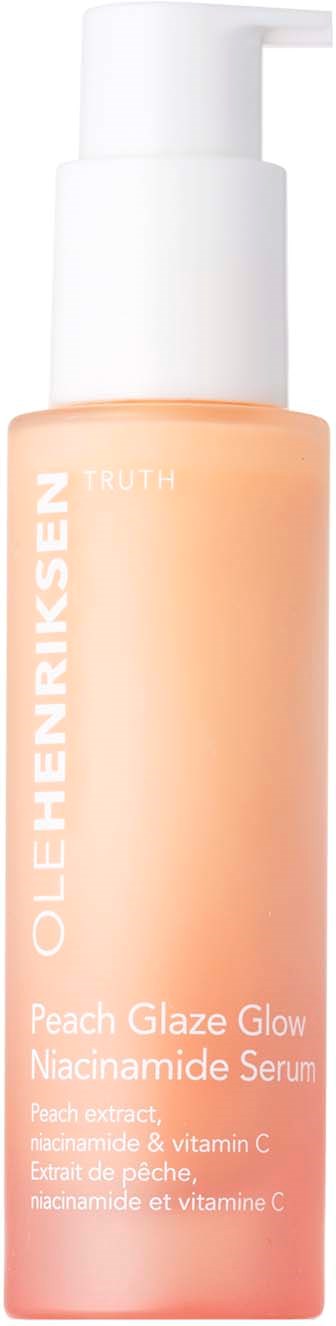 Een perzikkleurige fles met een witte pomp, gelabeld "OLEHENRIKSEN Peach Glaze Glow Niacinamide Serum."