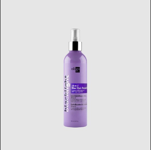 Een paarse fles haarverzorgingsproduct met witte spraykop en zwarte details op het etiket.