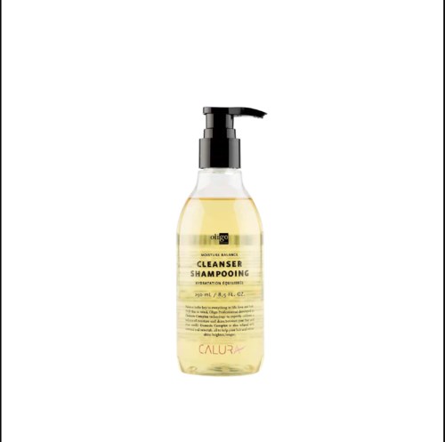 Een doorzichtige fles met een zwart pompje, gelabeld als Calura Cleanser Shampoo, bevat gele vloeistof.