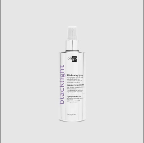 Een witte sprayfles met label "oligo black light" voor haar, met spraykop en productdetails.