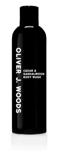 Een zwarte fles Olivier J. Woods ceder- en sandelhout lichaamswas met witte tekst.