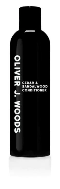 Een zwarte fles met witte tekst voor ceder en sandelhout conditioner. Het merk is Oliver J. Woods.