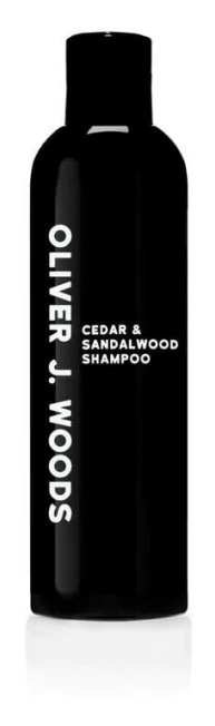 Een zwarte fles met witte tekst zegt Oliver J. Woods Cedar & Sandalwood Shampoo.