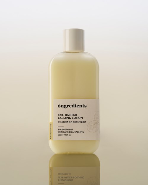 Beigeerä pullo rauhoittavaa lotionia nimeltä 'Skin Barrier Calming Lotion' ja valkoinen kansi.