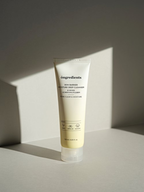 A white tube of skincare cream with text on it, placed on white surface with a shadow cast by light.