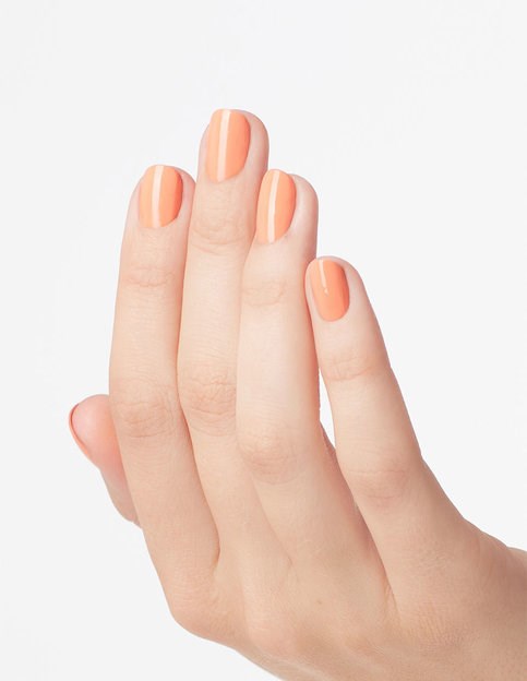 En hand med välmålade naglar har persikofärgad nagellack med vita ränder.