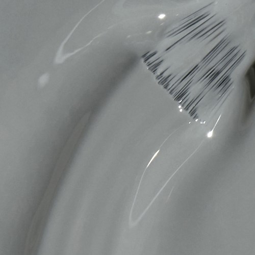 A shiny, silver surface with some reflections and a barcode sticker on the top right.