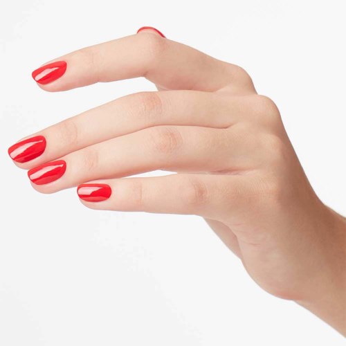 A hand with red nail polish showing on fingers. The background is plain and light-colored.