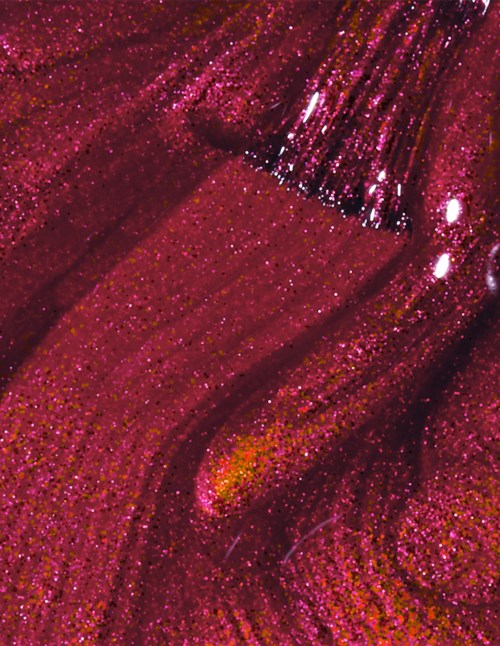Bilden visar en närbild av rosa glitternagellack med glansiga ränder och glitterstänk.