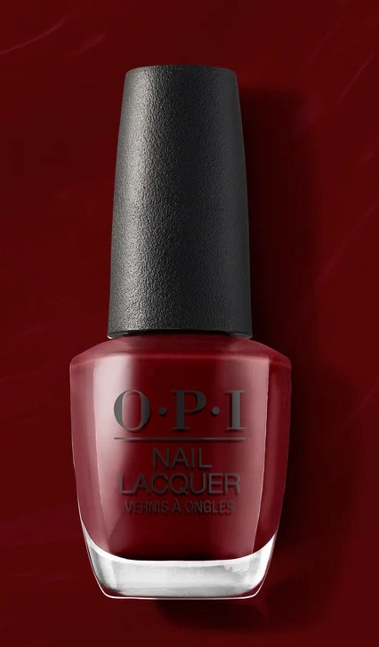 Red nail polish bottle with black cap, label reads O.P.I Nail Lacquer, on a dark red background.